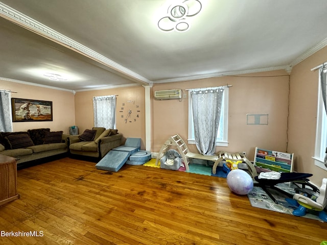 living room with a wall unit AC, wood-type flooring, and crown molding