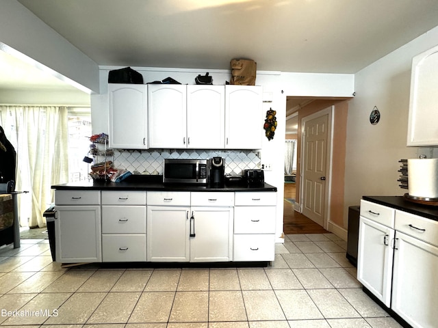 kitchen with white cabinets, light tile patterned flooring, and tasteful backsplash