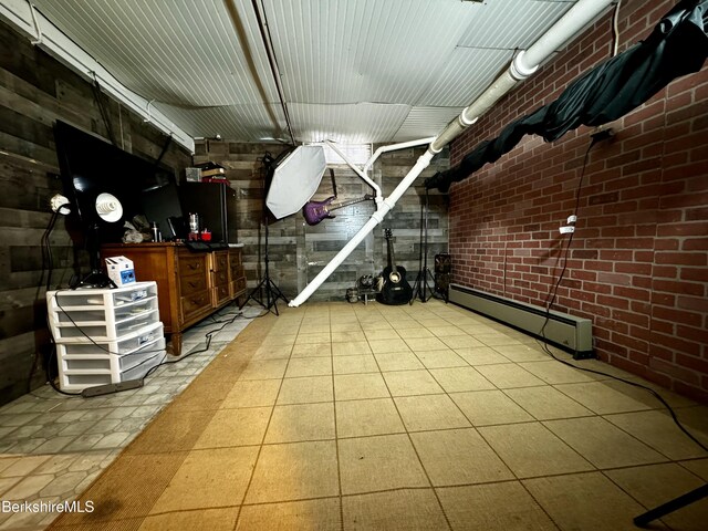 storage room featuring brick wall, baseboard heating, and light tile patterned flooring