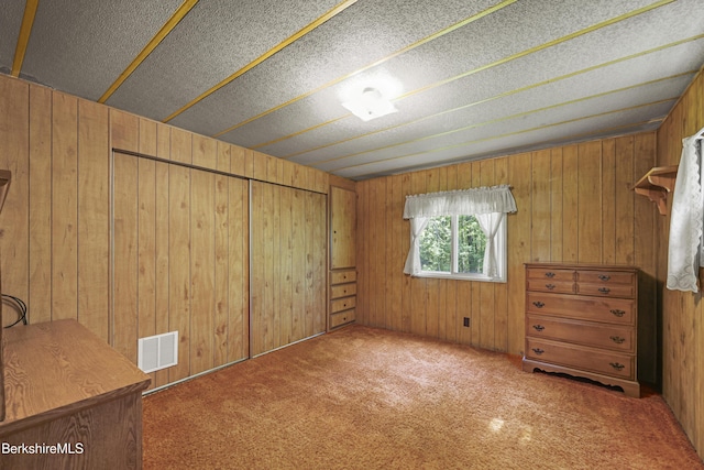 159 Black Brook Rd, Savoy, MA 01256 - unfurnished bedroom with wood walls, carpet floors, and a closet