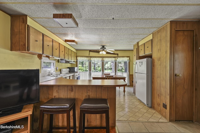 159 Black Brook Rd, Savoy, MA 01256 - kitchen featuring white appliances, a peninsula, ceiling fan, brown cabinetry, and under cabinet range hood