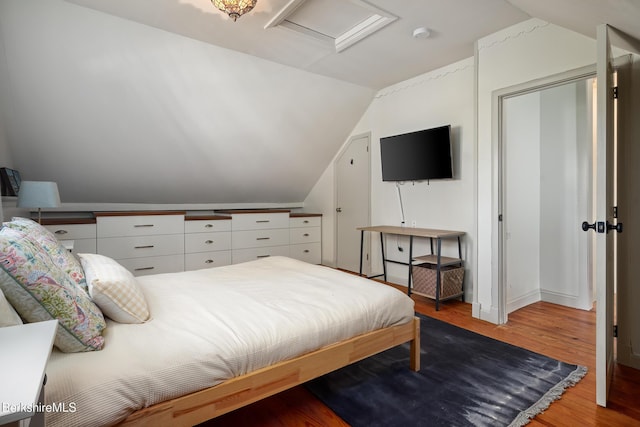 bedroom with light hardwood / wood-style floors and vaulted ceiling