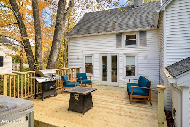 wooden deck featuring area for grilling, a fire pit, and french doors