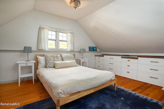 bedroom with hardwood / wood-style flooring and vaulted ceiling