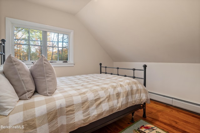 bedroom with hardwood / wood-style floors, baseboard heating, and vaulted ceiling