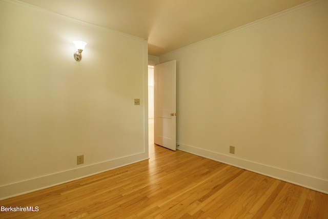 empty room with light hardwood / wood-style floors and ornamental molding