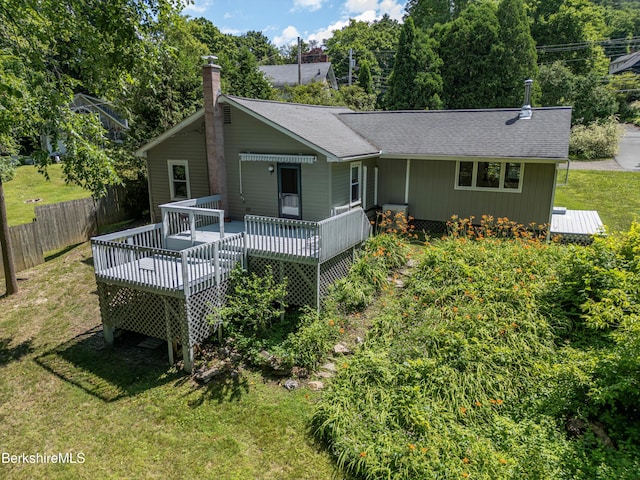 rear view of house featuring a lawn and a wooden deck