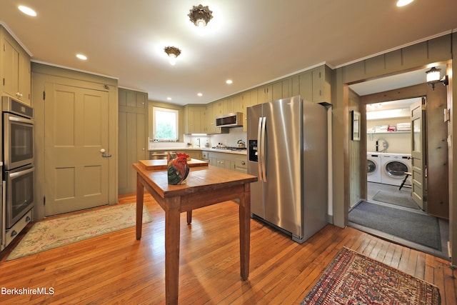 49 Main St, Stockbridge, MA 01262 - kitchen with stainless steel appliances, washing machine and dryer, light wood-style floors, light countertops, and crown molding