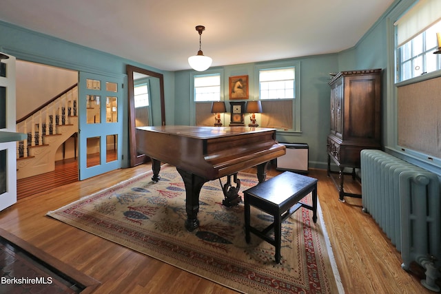 49 Main St, Stockbridge, MA 01262 - living area with radiator heating unit, stairs, and light wood-style flooring