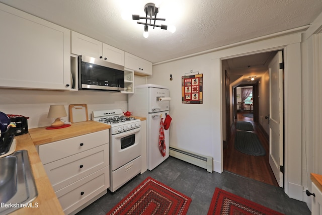 49 Main St, Stockbridge, MA 01262 - kitchen with white appliances, a baseboard heating unit, white cabinetry, and wooden counters