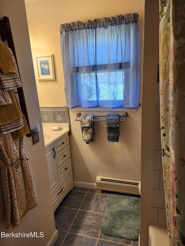 bathroom featuring vanity, baseboards, a shower with shower curtain, a bathtub, and baseboard heating
