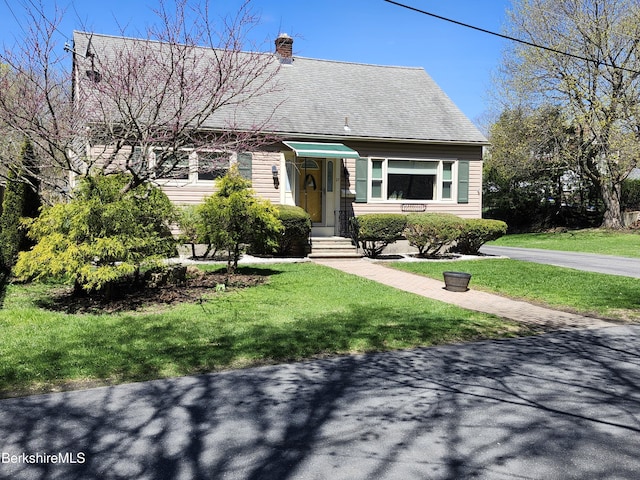view of front facade featuring a front lawn and a chimney