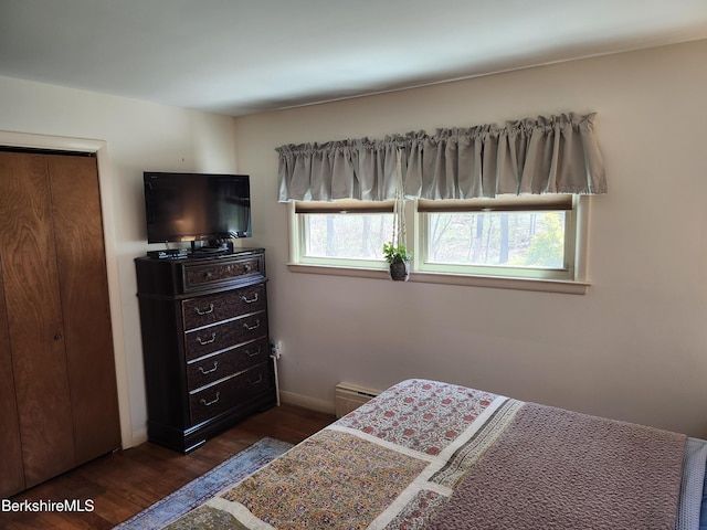 bedroom with baseboards and dark wood-type flooring
