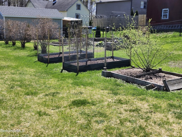 view of yard featuring fence and a vegetable garden