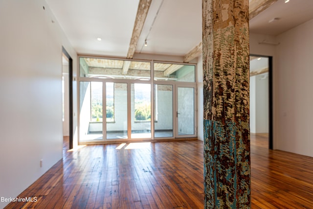 empty room featuring floor to ceiling windows and dark wood-type flooring