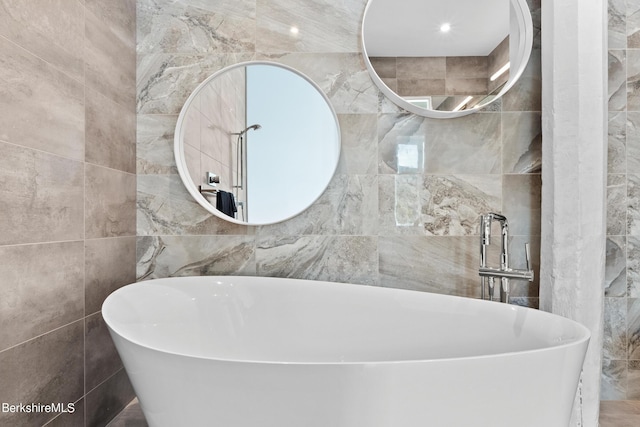 bathroom with a bath and tile walls