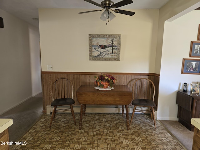 carpeted dining room with ceiling fan and a baseboard radiator