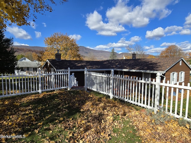 exterior space with a fenced front yard and a mountain view