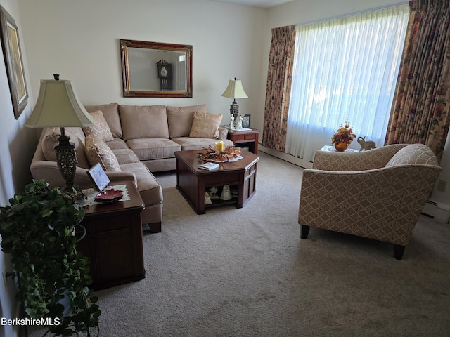 carpeted living room with a baseboard heating unit