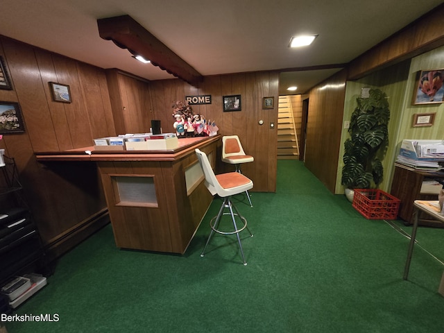 bar with dark carpet, wood walls, beamed ceiling, and stairs