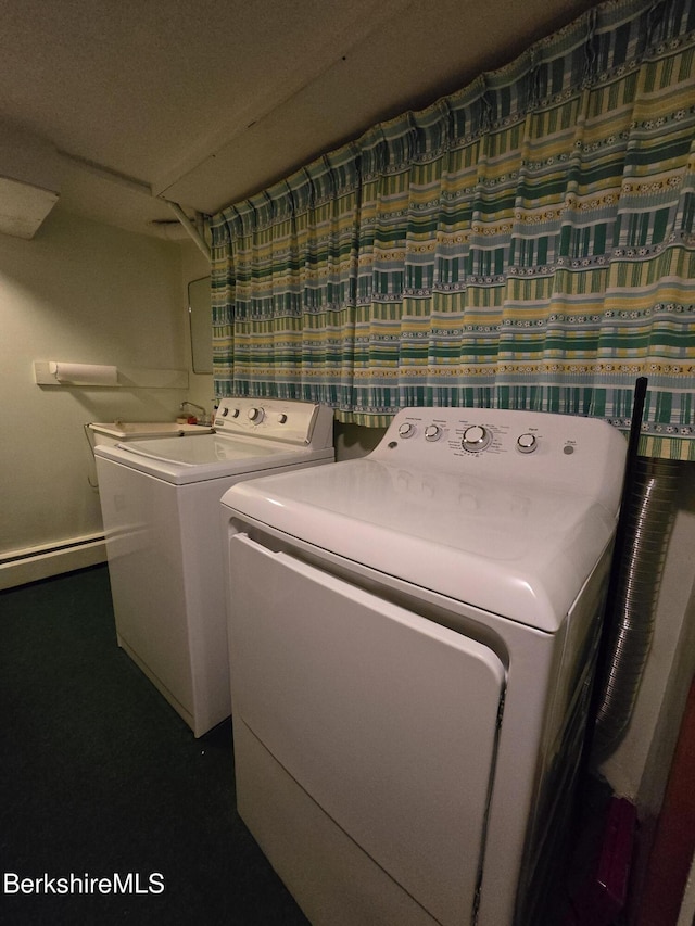 clothes washing area featuring laundry area, baseboard heating, and washer and dryer