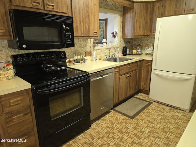 kitchen featuring a sink, black appliances, tasteful backsplash, and light countertops