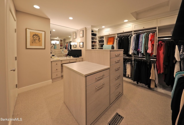 walk in closet with light colored carpet