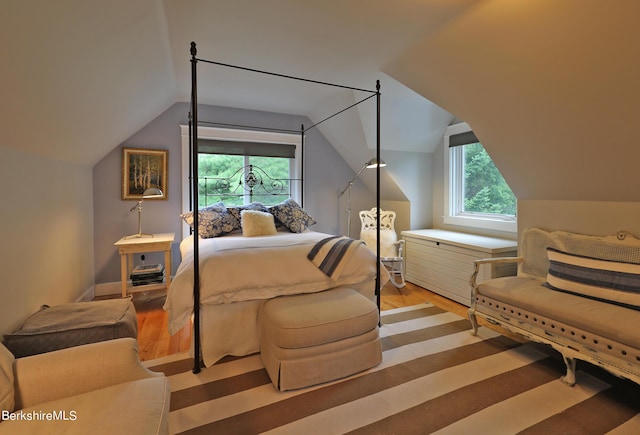 bedroom featuring wood-type flooring and vaulted ceiling