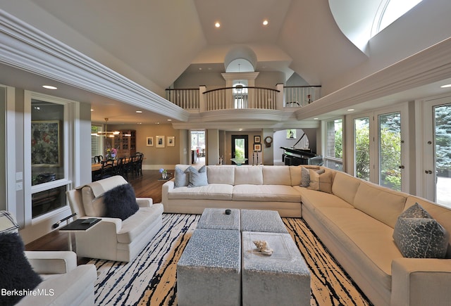 living room with a wealth of natural light, high vaulted ceiling, and hardwood / wood-style flooring