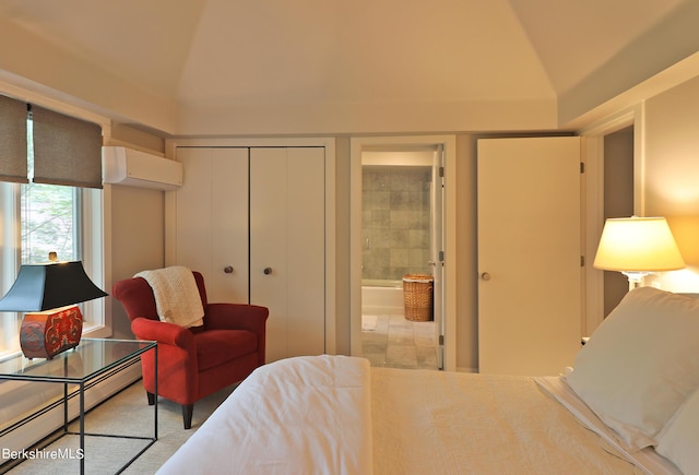 bedroom featuring an AC wall unit, ensuite bathroom, lofted ceiling, and baseboard heating