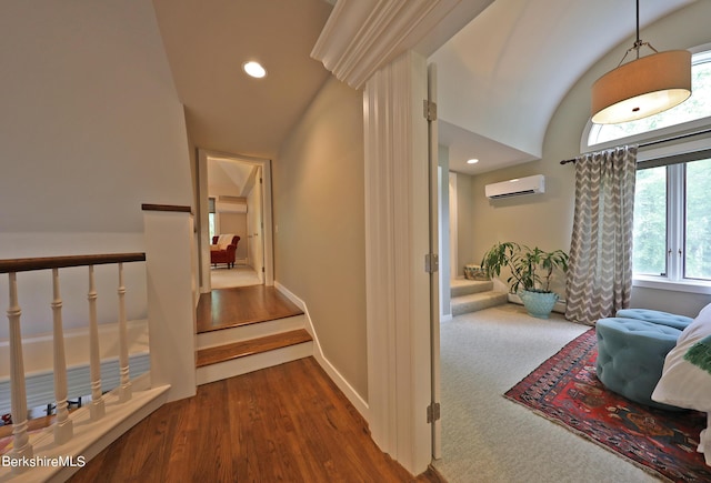 hallway with a wall unit AC and hardwood / wood-style floors