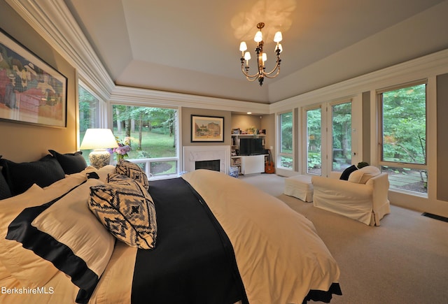 bedroom with carpet flooring, a notable chandelier, and a tray ceiling