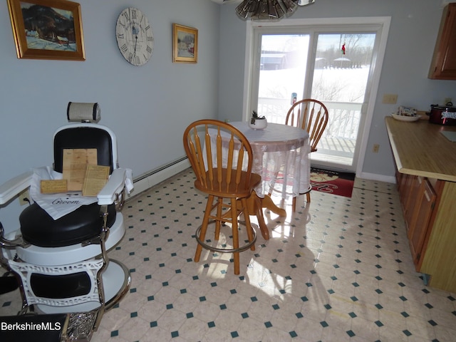 dining space featuring light floors and baseboards