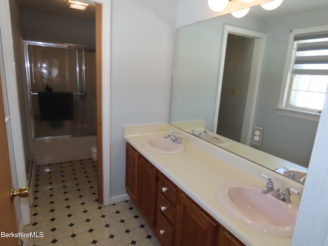 full bath featuring a sink, toilet, and double vanity