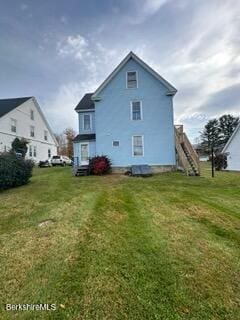 rear view of house featuring a yard