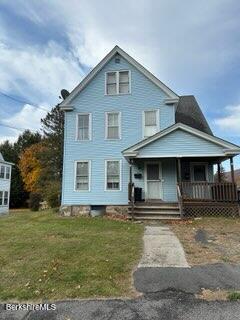 view of front of house with a porch and a front yard