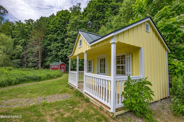 view of outbuilding featuring a lawn and covered porch