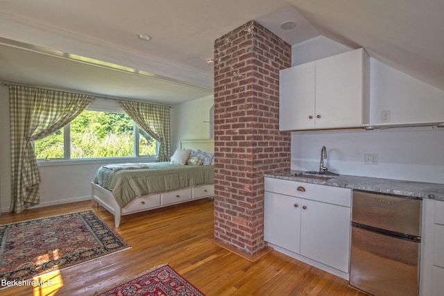 bedroom with refrigerator, lofted ceiling, sink, and light hardwood / wood-style flooring