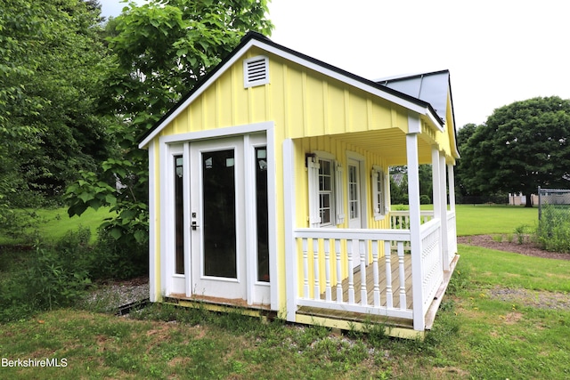 view of outdoor structure with a porch and a yard