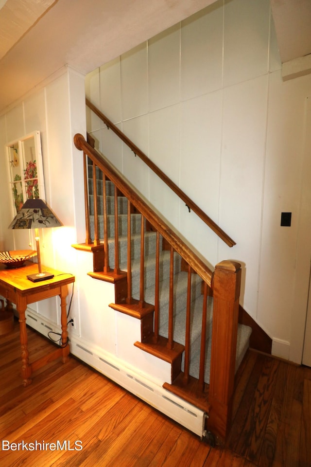 staircase with hardwood / wood-style flooring and a baseboard radiator