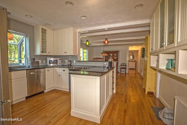 kitchen featuring kitchen peninsula, white cabinets, beam ceiling, dishwasher, and hanging light fixtures