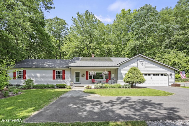 83 Bradley St, North Adams, MA 01247 - ranch-style house with a porch, asphalt driveway, roof mounted solar panels, an attached garage, and a front lawn