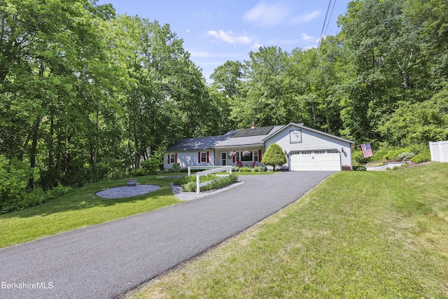 83 Bradley St, North Adams, MA 01247 - ranch-style home featuring solar panels, asphalt driveway, a front yard, a garage, and a chimney