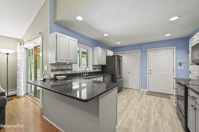 83 Bradley St, North Adams, MA 01247 - kitchen featuring stainless steel appliances, dark stone countertops, light wood finished floors, a peninsula, and recessed lighting