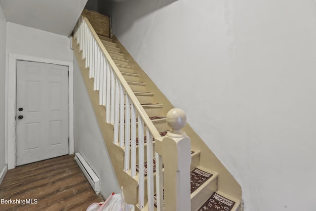 staircase with wood-type flooring and baseboard heating