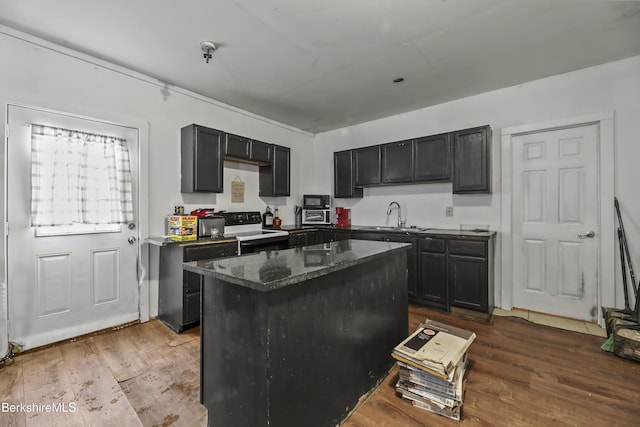 kitchen with a kitchen island, dark stone countertops, sink, black electric range oven, and hardwood / wood-style flooring