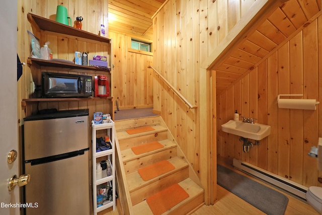 235 Algerie Rd, Becket, MA 01223 - stairway featuring wood ceiling, wood walls, a baseboard heating unit, and wood finished floors