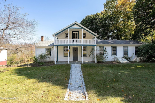 view of front of property with a balcony, a porch, and a front yard