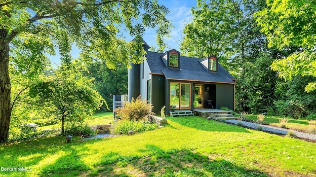back of house with a yard and a shingled roof