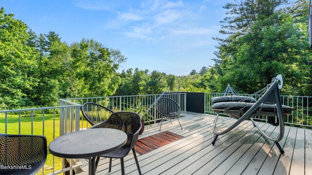 wooden deck featuring a lawn
